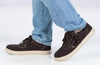 Person wearing Men&#39;s Dark Brown/White Stitch BILLY Sneaker Low Tops, ideal for diabetes, plantar fasciitis, and wide feet needs.